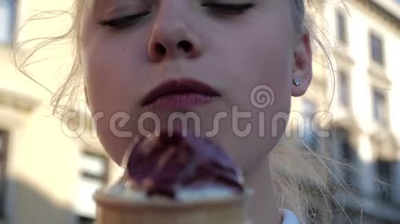 性感的金发女孩站在克拉科夫夏天在斯洛文尼亚吃冰淇淋视频的预览图