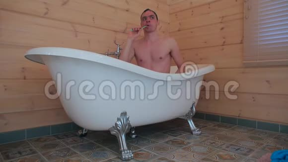 一个男人坐在浴室里刷牙视频的预览图