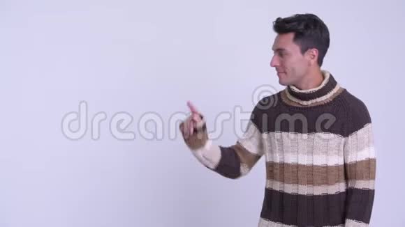 年轻快乐的西班牙裔男子摸着东西交叉双臂准备过冬视频的预览图
