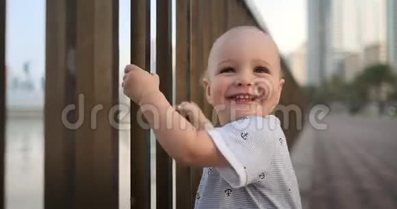 男孩笑了笑看着夏天站在水边的摄像机拿着栏杆视频的预览图