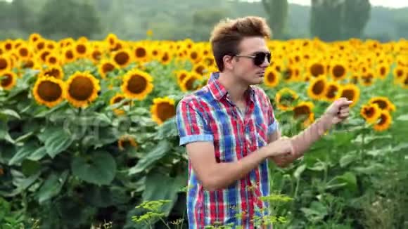 酷男农夫在向日葵球场上跳舞在日落时感到高兴和积极农业概念视频的预览图