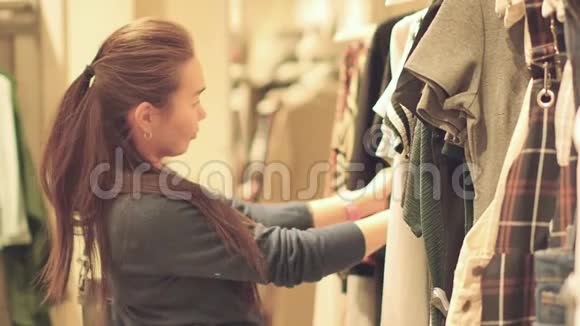 一位亚洲美女正在一家女装店购物一开始买暖和的衣服视频的预览图