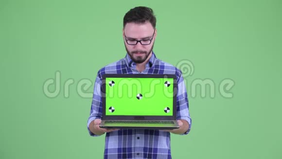 穿着有胡子的年轻时髦男人带着笔记本电脑视频的预览图