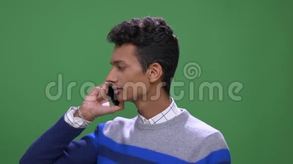 年轻迷人的印度男性特写镜头电话背景与绿色隔离视频的预览图
