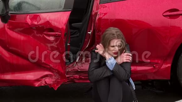 一个女孩坐在一辆破车附近的地上她出了车祸视频的预览图
