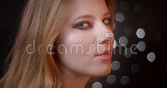 迷人的生姜模型与明亮和生动的化妆调情相机是诱人的bokeh背景视频的预览图