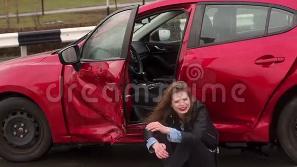 一个女孩坐在一辆破车附近的地上她出了车祸视频的预览图