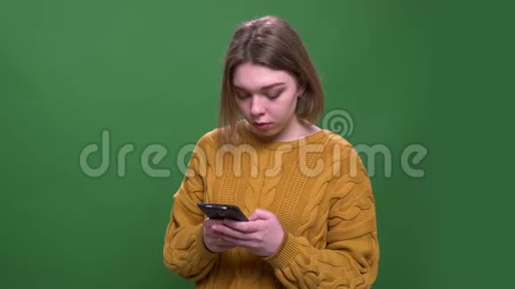 年轻漂亮的短发女性使用手机近距离拍摄背景与摄像头隔离视频的预览图