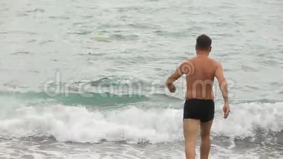 生活方式的人在卵石滩上走进大海在波浪上游泳视频的预览图