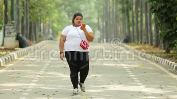 超重的年轻女子在公园散步视频的预览图