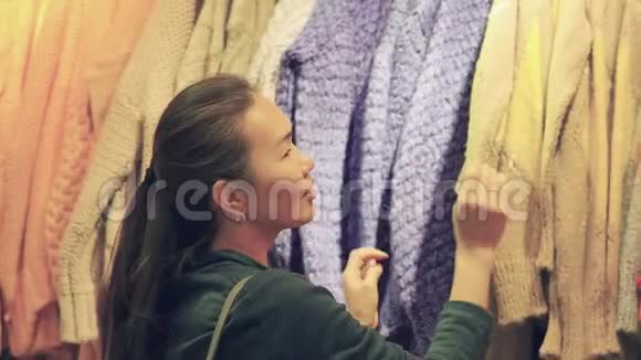 一位亚洲美女正在一家女装店购物一开始买暖和的衣服视频的预览图