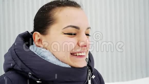 开朗的女孩笑了舌头在雪下捕捉雪花视频的预览图