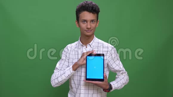 印度年轻男性的特写镜头使用平板电脑用蓝屏拍摄背景视频的预览图