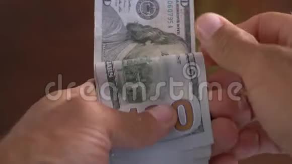 一个商人手中数着一百美元钞票的特写镜头视频的预览图