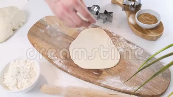 一个男人用白板桌上的饼干面团切了一个星形的饼干闭合视频的预览图