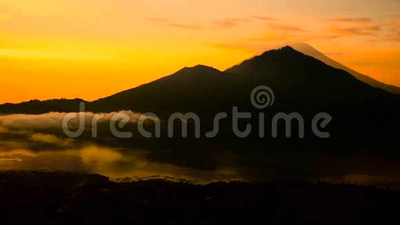 太阳升起在巴图尔湖火山阿贡和阿邦的背景上巴厘视频的预览图