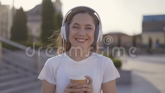 一位美丽开朗的年轻女子在街上散步时竖起大拇指的肖像视频的预览图