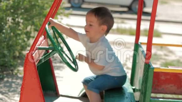 可爱的小男孩的特写镜头无忧无虑地玩汽车司机户外日落幸福无忧无虑的童年概念视频的预览图
