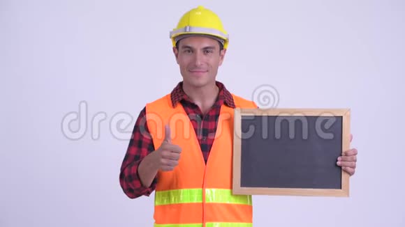 年轻快乐的西班牙裔建筑工人拿着黑板竖起大拇指视频的预览图