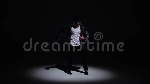 年轻时尚的男子舞蹈风格迈克尔杰克逊聚光灯在黑色背景视频的预览图