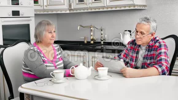 成熟的家庭女人和男人一起在家的白色厨房里享用早餐视频的预览图