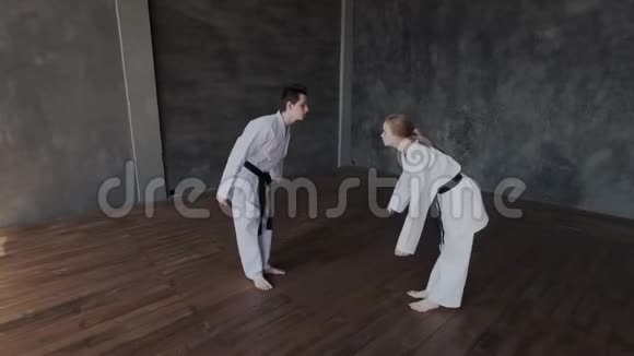 一个黑发男人和一个金发女孩正在健身房训练武术跆拳道学校的弹舞或单人决斗视频的预览图