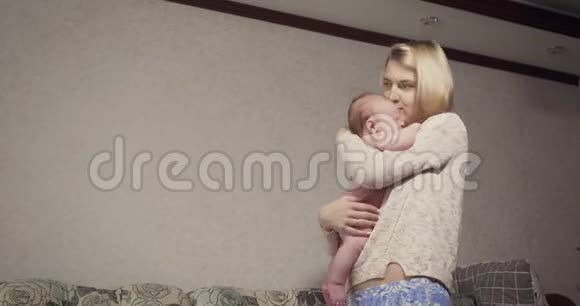 年轻的母亲抱着她的小宝贝女儿安慰她视频的预览图