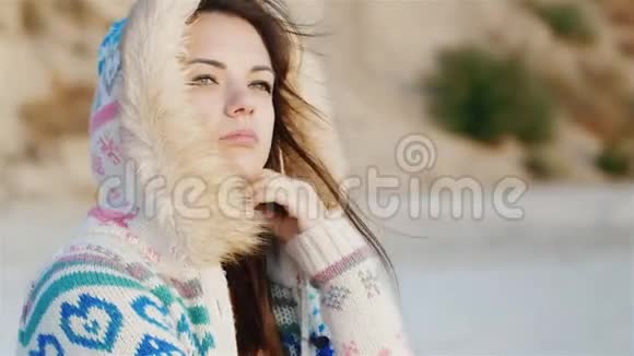 体贴的年轻女子坐在沙滩上风吹在她的脸上好天气做梦的时间视频的预览图