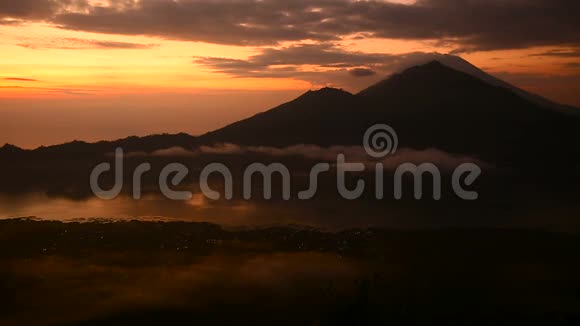 太阳升起在巴图尔湖火山阿贡和阿邦的背景上巴厘视频的预览图