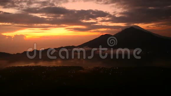 太阳升起在巴图尔湖火山阿贡和阿邦的背景上巴厘视频的预览图