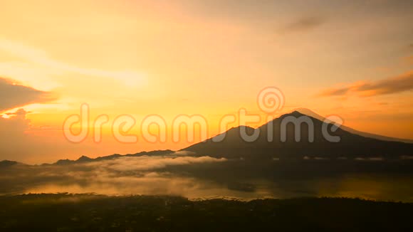 太阳升起在巴图尔湖火山阿贡和阿邦的背景上巴厘视频的预览图
