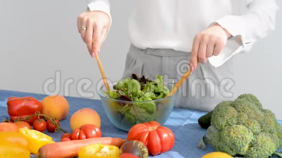 贴身女人正在厨房里混合新鲜蔬菜沙拉配料视频的预览图