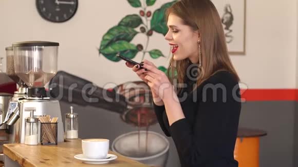 一个漂亮的十几岁的女孩在一家咖啡馆里喝杯咖啡自拍慢动作视频的预览图