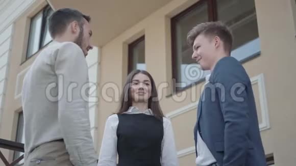 年轻的女人和两个正式的男人一起穿高五在露台上商业关系自由职业概念视频的预览图