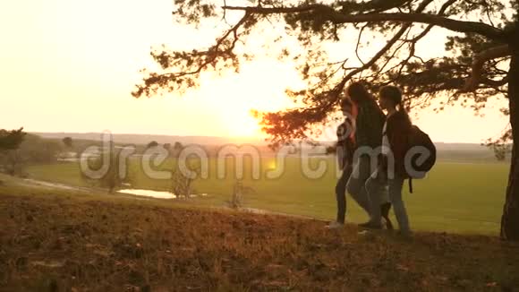 妇儿旅行漫步林中欣赏夕阳下的景色旅行者妈妈和女儿一起旅行视频的预览图