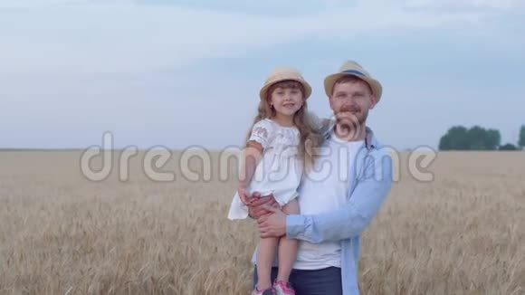快乐的爸爸和小女孩的肖像年轻人和快乐的女儿站在一起双手相视视频的预览图