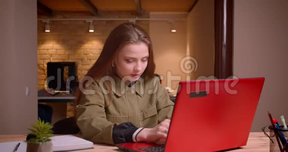 年轻少女用笔记本电脑工作的肖像获得成功在办公室获得快乐视频的预览图