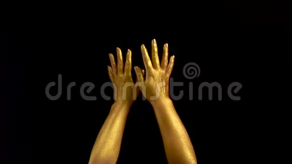 女性黄金手势的漂亮镜头黑色背景手放在黑色背景上的金色油漆里视频的预览图