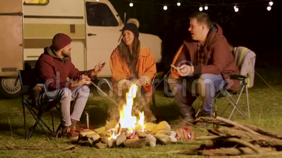 一个留着胡子的人在篝火旁跟朋友们讲笑话视频的预览图