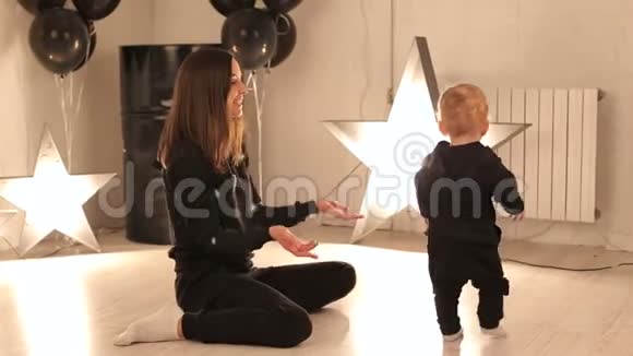 一个年轻的女人和一个小儿子在一个有着燃烧的星星的房间里的肖像视频的预览图