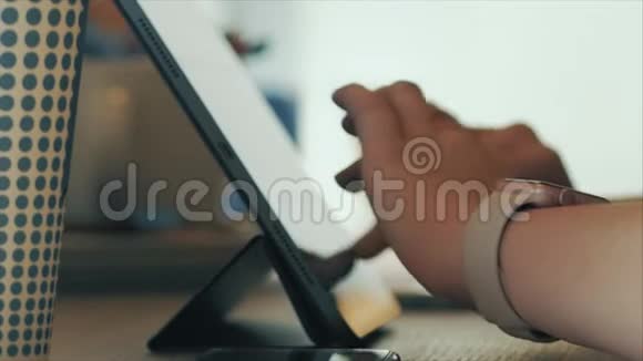 年轻女子坐在咖啡馆里在平板电脑上网上购物网店的概念视频的预览图