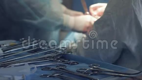 双手持血操作戴防护手套的护士在手术期间为医生提供手术器械视频的预览图