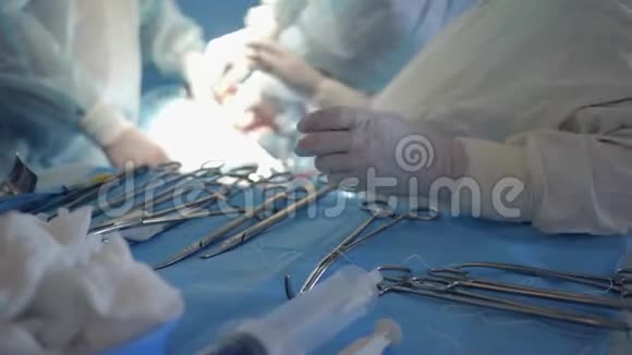 手术工具戴手套的护士在手术过程中用棉签擦拭血液并准备干净的仪器以供治疗视频的预览图