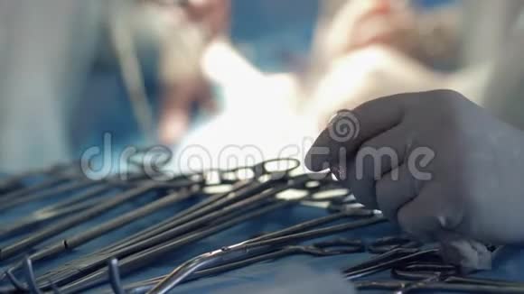 外科治疗护士双手戴着血手套靠近手术工具接近医生的模糊背景视频的预览图