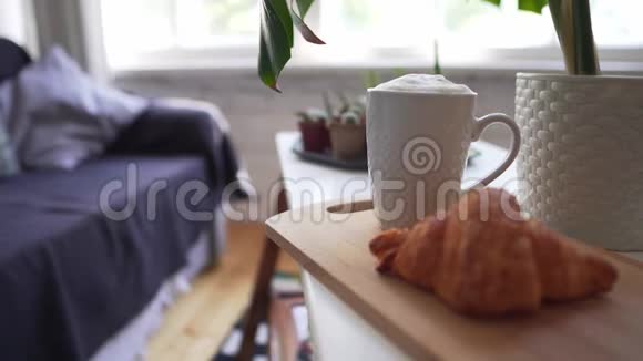 软沙发背景上的热咖啡和自制牛角面包湿视频的预览图