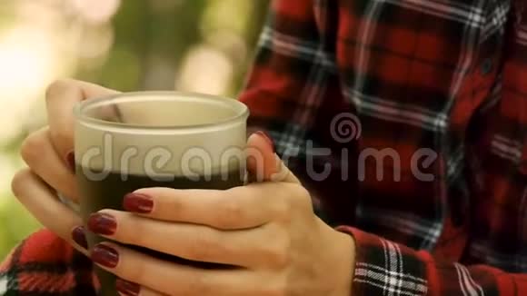 特写镜头一只雌性的手拿着一杯咖啡带到她的嘴唇上大自然视频的预览图