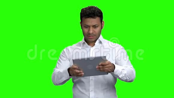 狂热的印度男人在平板电脑上玩游戏视频的预览图