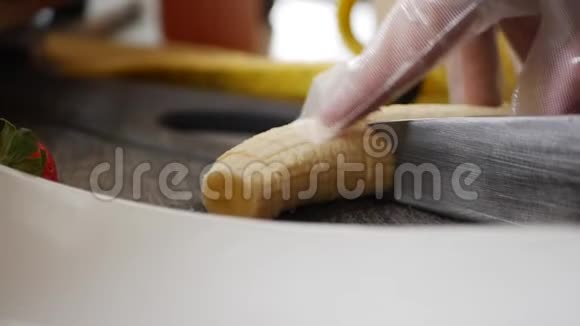 厨师用手套用小刀切香蕉做甜点或甜点视频的预览图