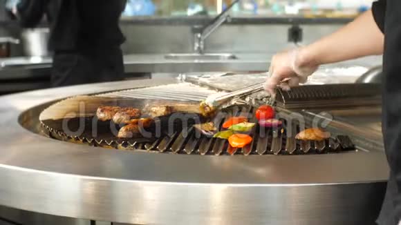 在一家餐馆里厨师把蔬菜炒成烤肉多汁牛肉肉排蔬菜视频的预览图