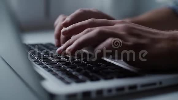 男人的手在笔记本电脑键盘上打字特写视频的预览图